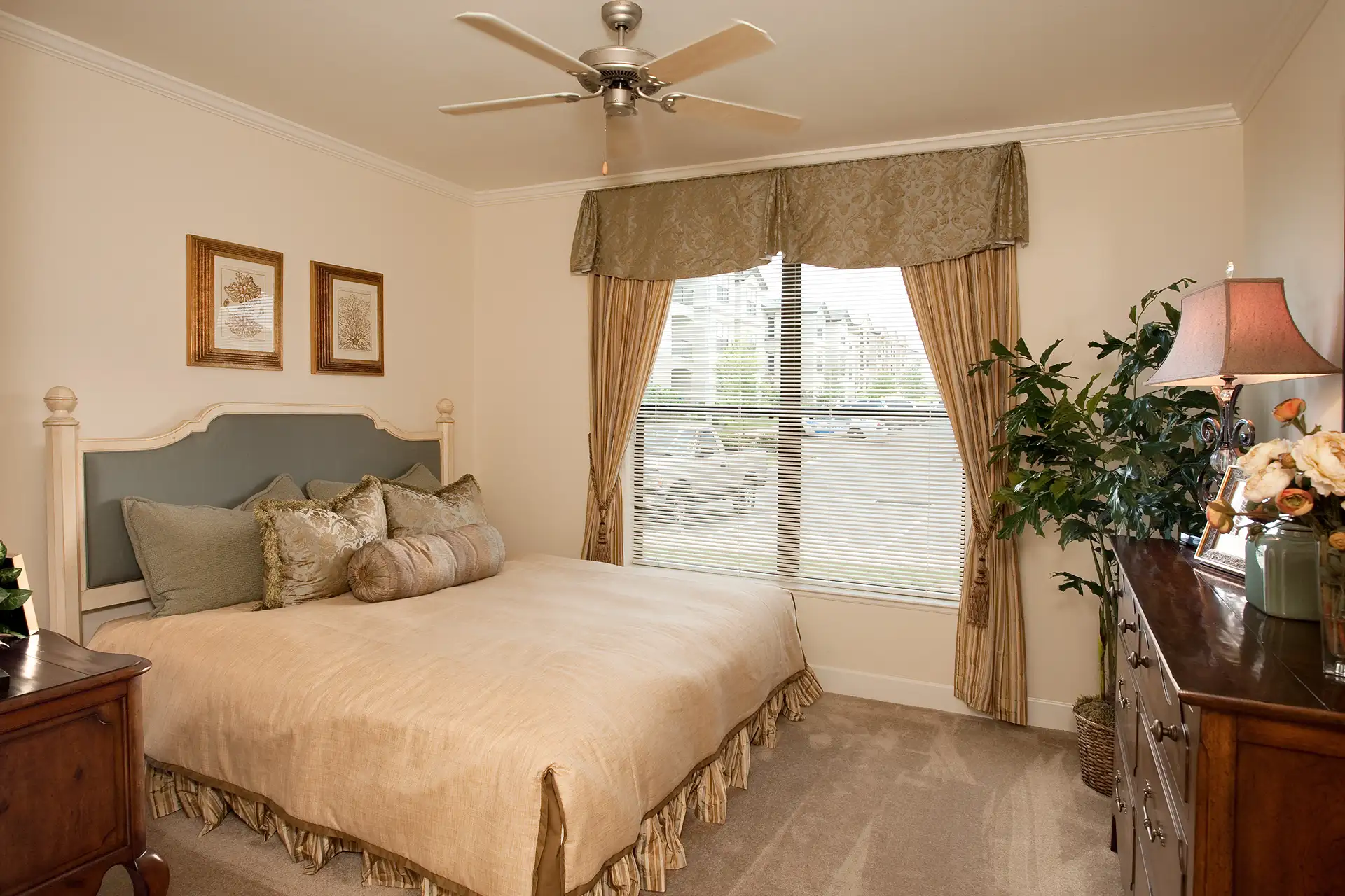 Model bedroom with ceiling fan and natural light at The Quarters Apartment Homes