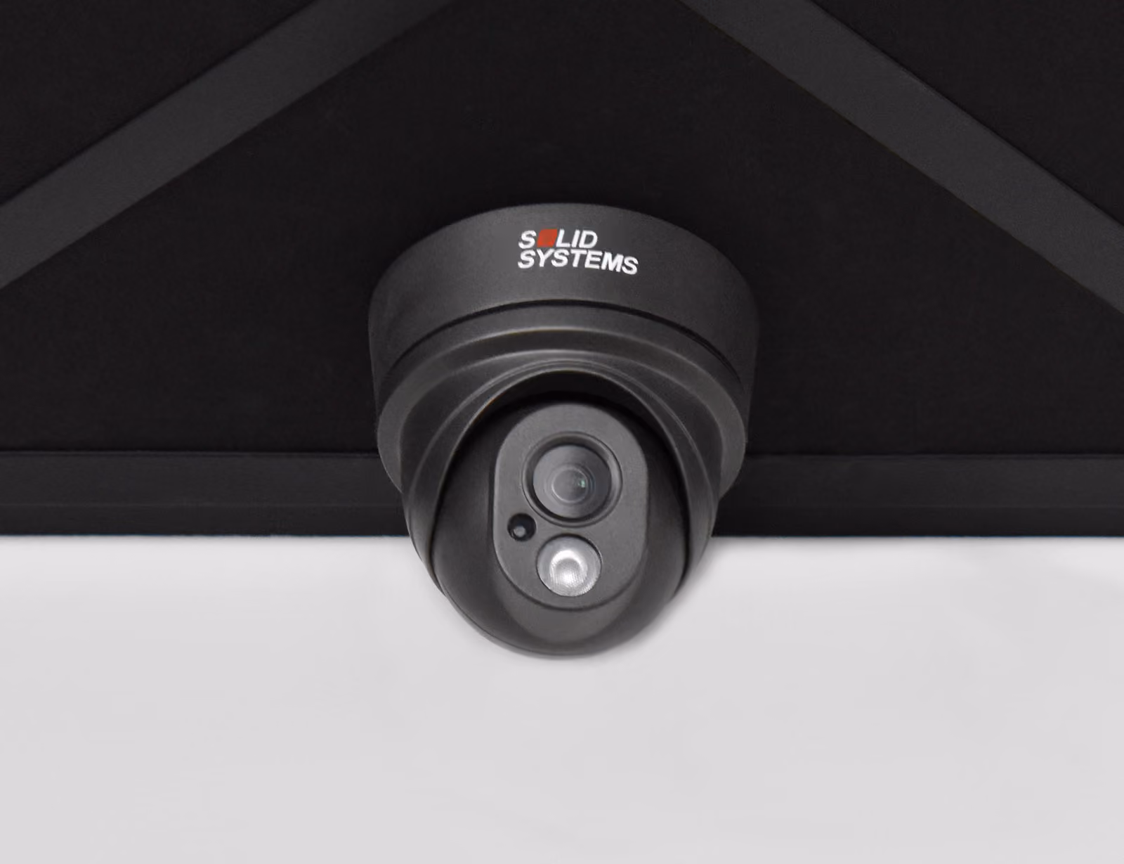 Een zwarte camera van Solid Systems tegen het plafond.
