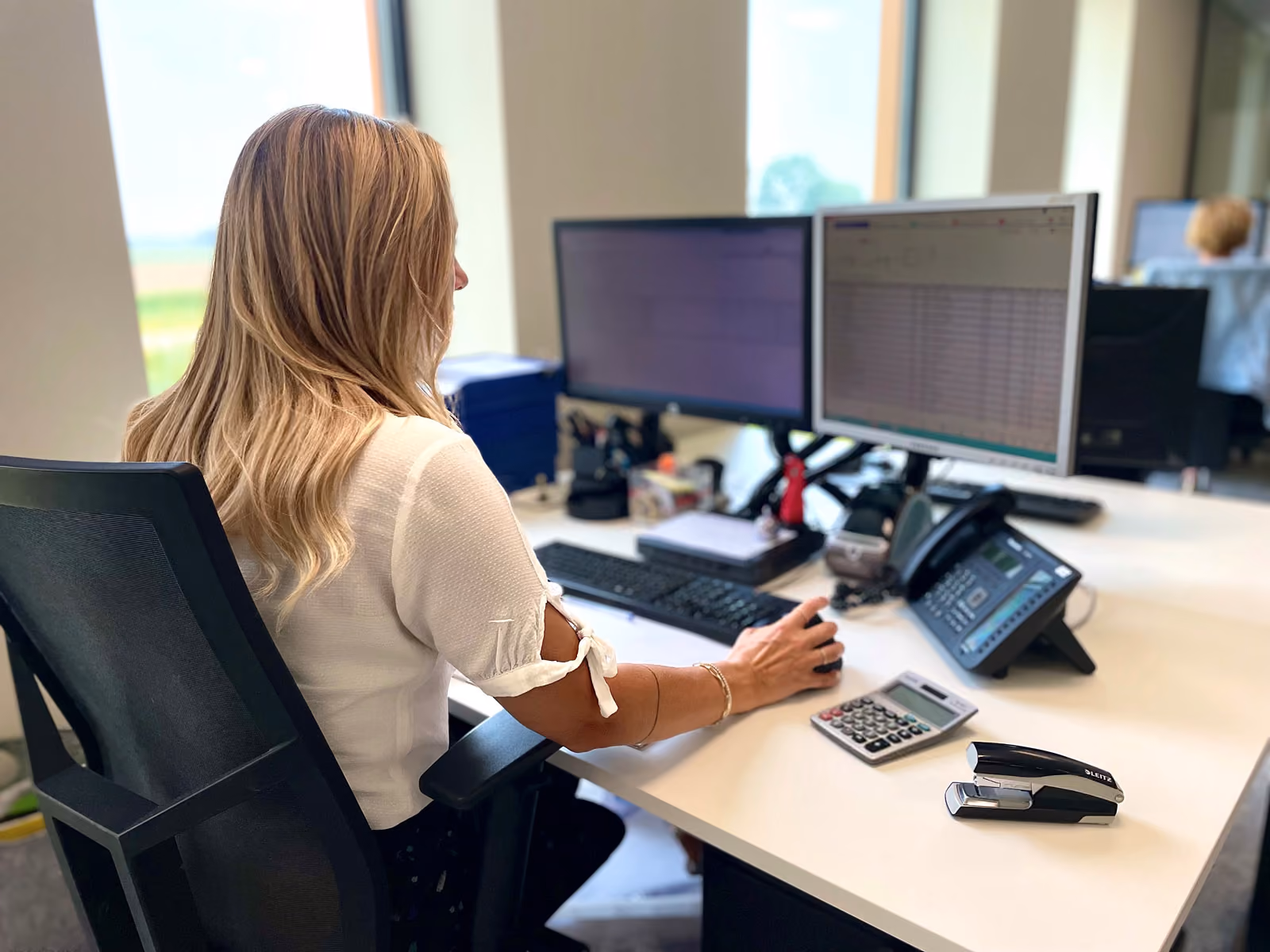 Vrouwelijke collega van Solid Systems  achter haar bureau. 