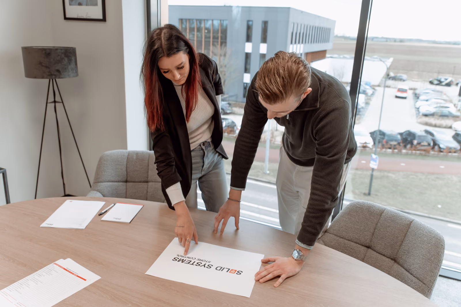 Intensief overleg tussen een mannelijke en vrouwelijk medewerker van Solid Systems in een kantooromgeving. 