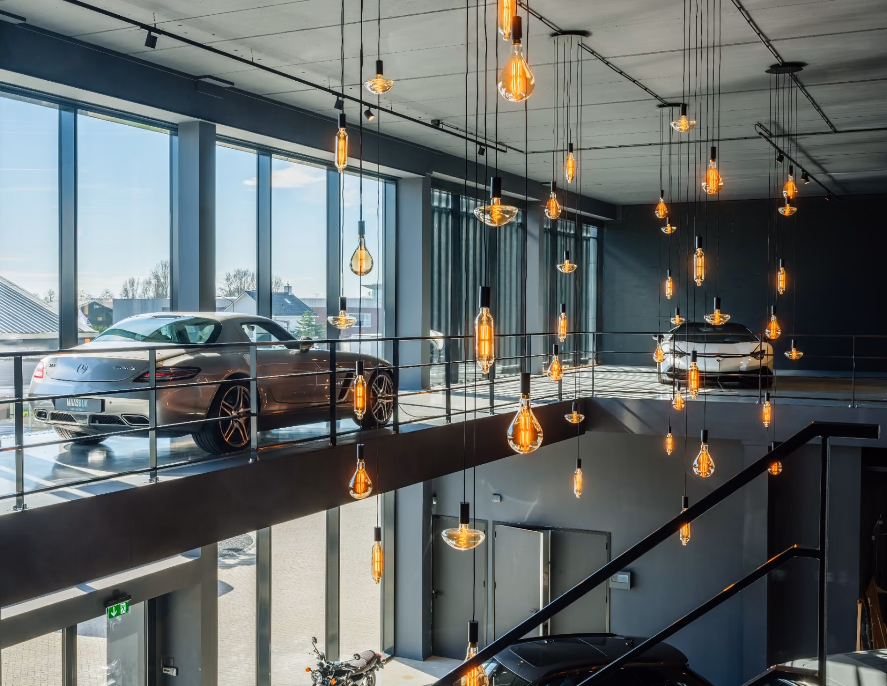 Moderne en ruime showroom met luxe auto's en mooie plafondverlichting. 