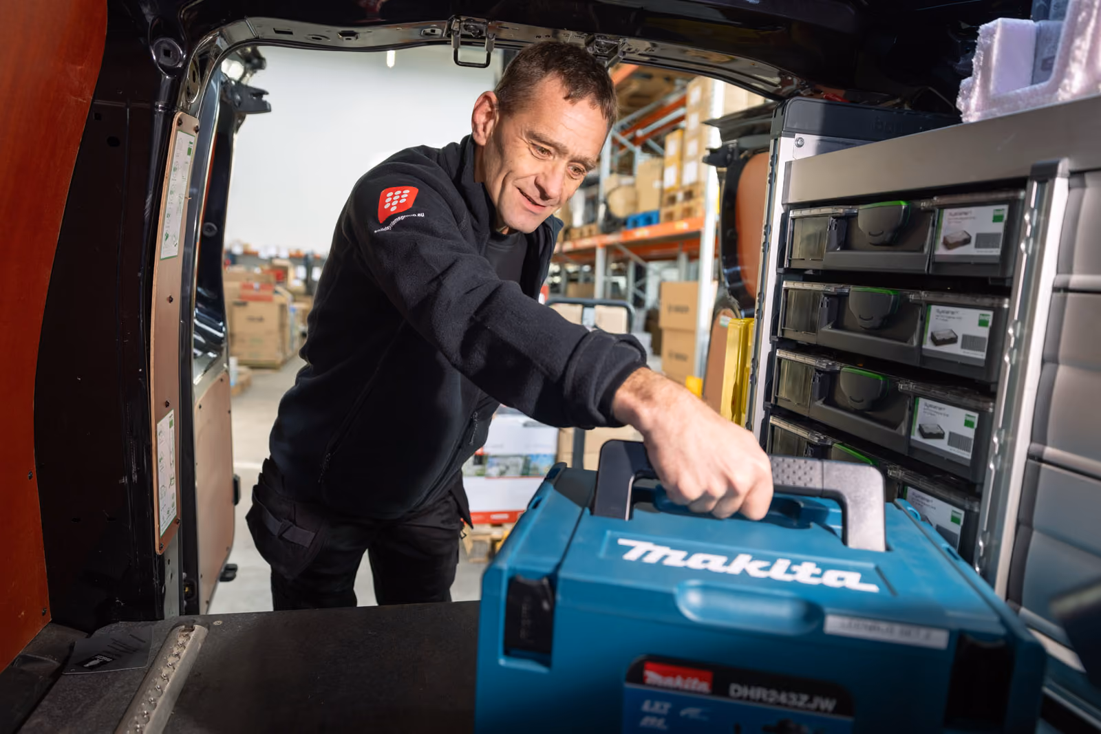 Een monteur van Solid Systems haalt zijn gereedschap uit zijn bus. 