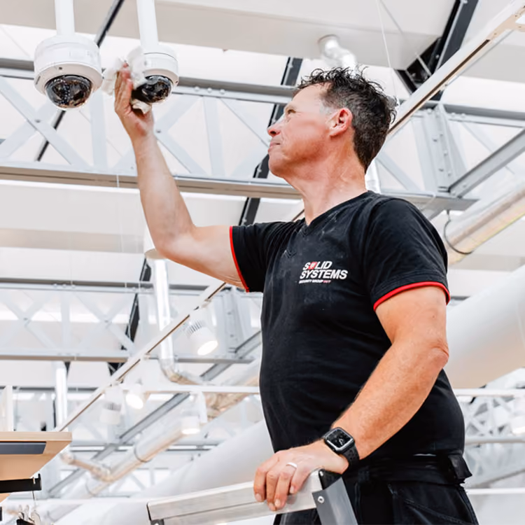 Een servicemonteur van Solid Systems controleert de beveiligingscamera's. 