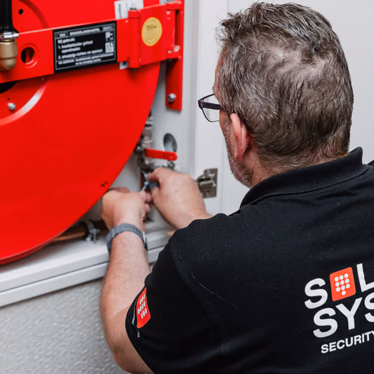 Een blusmiddelen expert van Solid systems controleert een brandslang. 