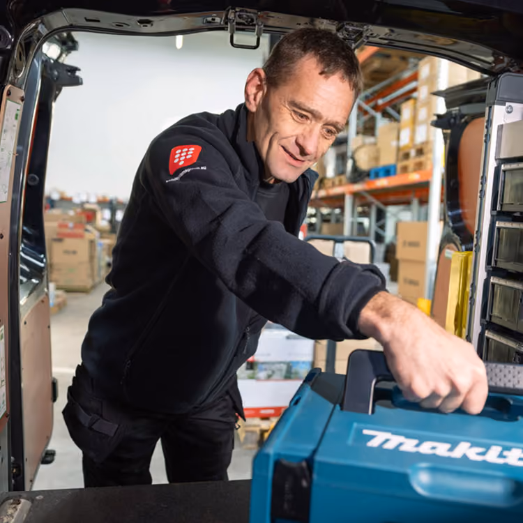 Een monteur van Solid Systems haalt zijn gereedschap uit zijn bus. 