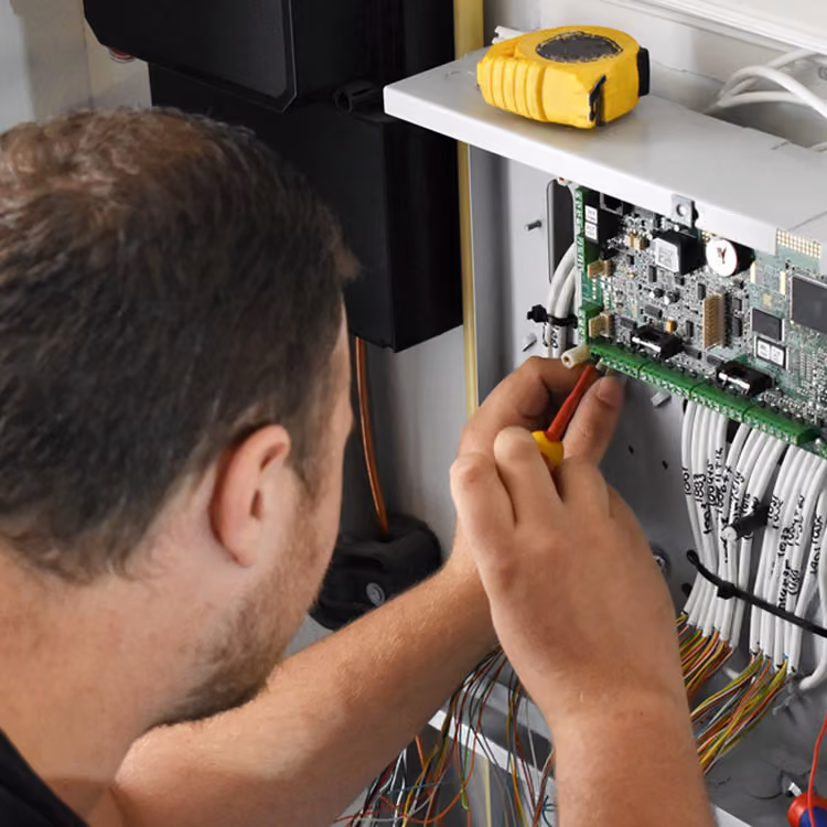 Installatiemonteur elektrotechniek van Solid Systems bevestigd bedrading in de patchkast.  