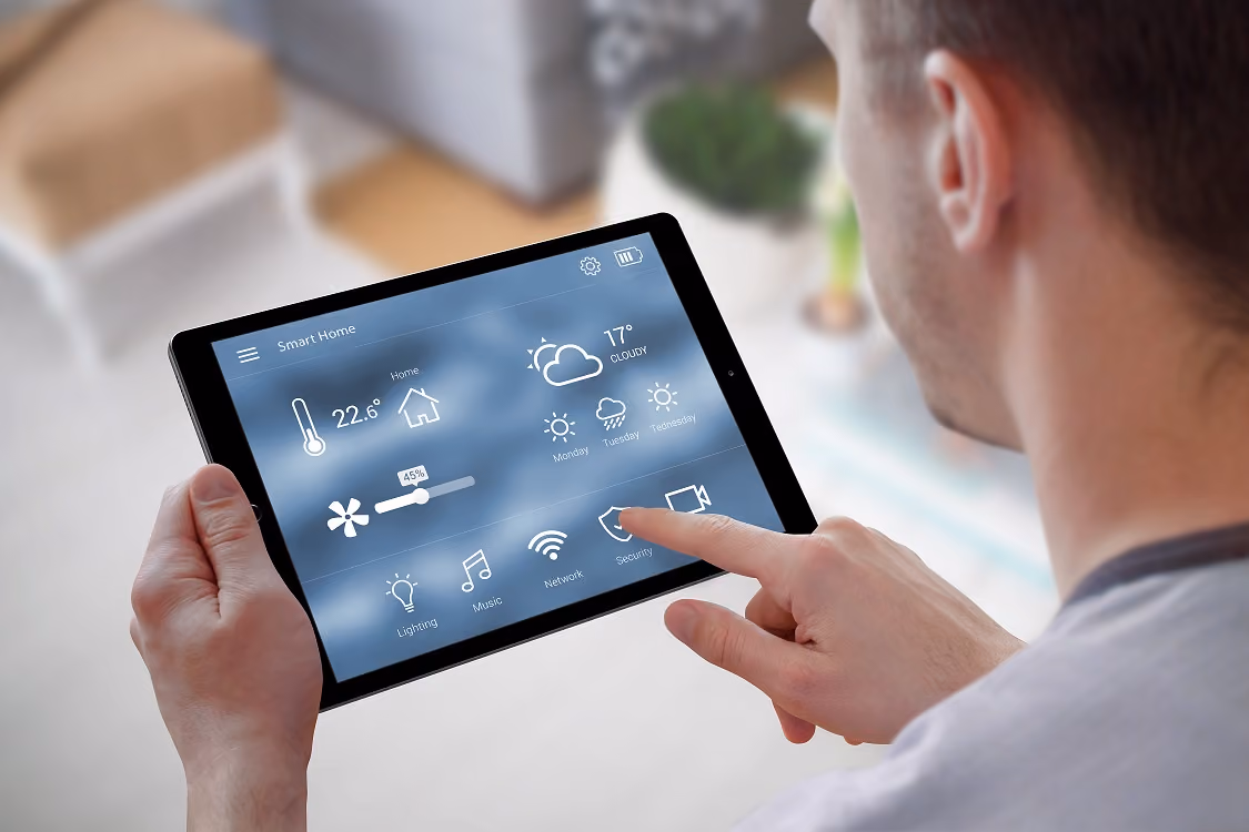 Kijkend over de schouder van een man naar een tablet met hierop zijn energiebeheersing. 