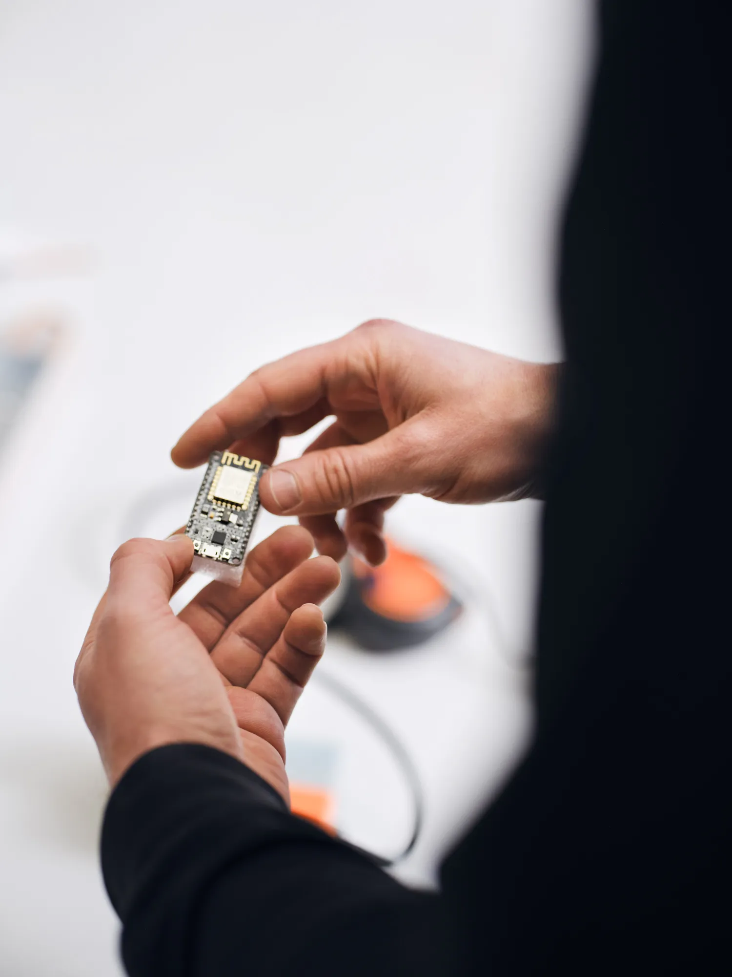 Person holding a small electronic circuit board in their hands.