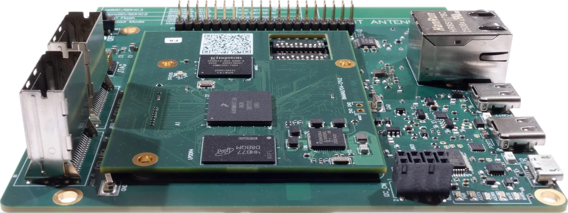 Close-up of a green printed circuit board with multiple integrated circuits, ports, pins, and connectors.