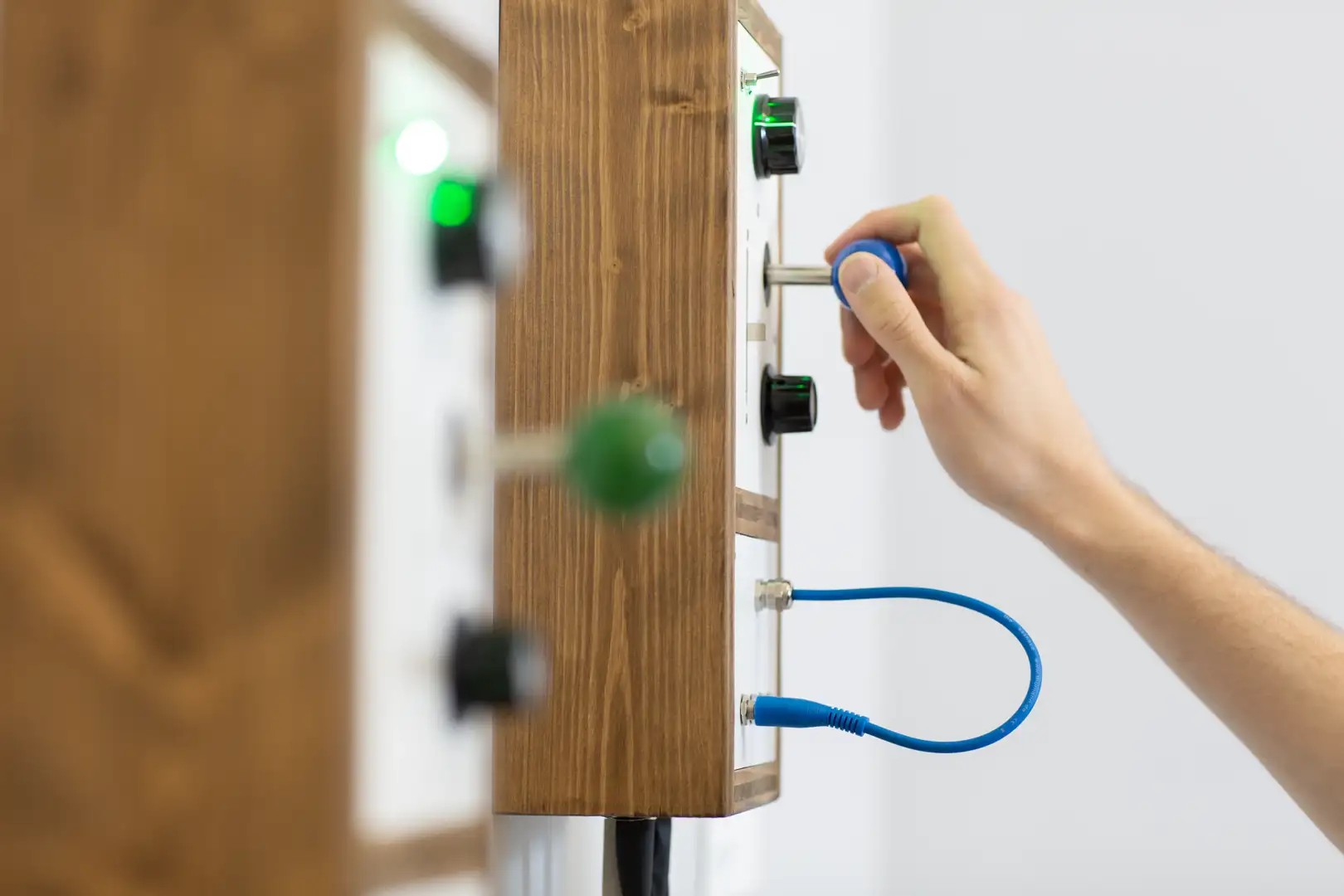Hand interacting with tactile joystick interface for collage installation