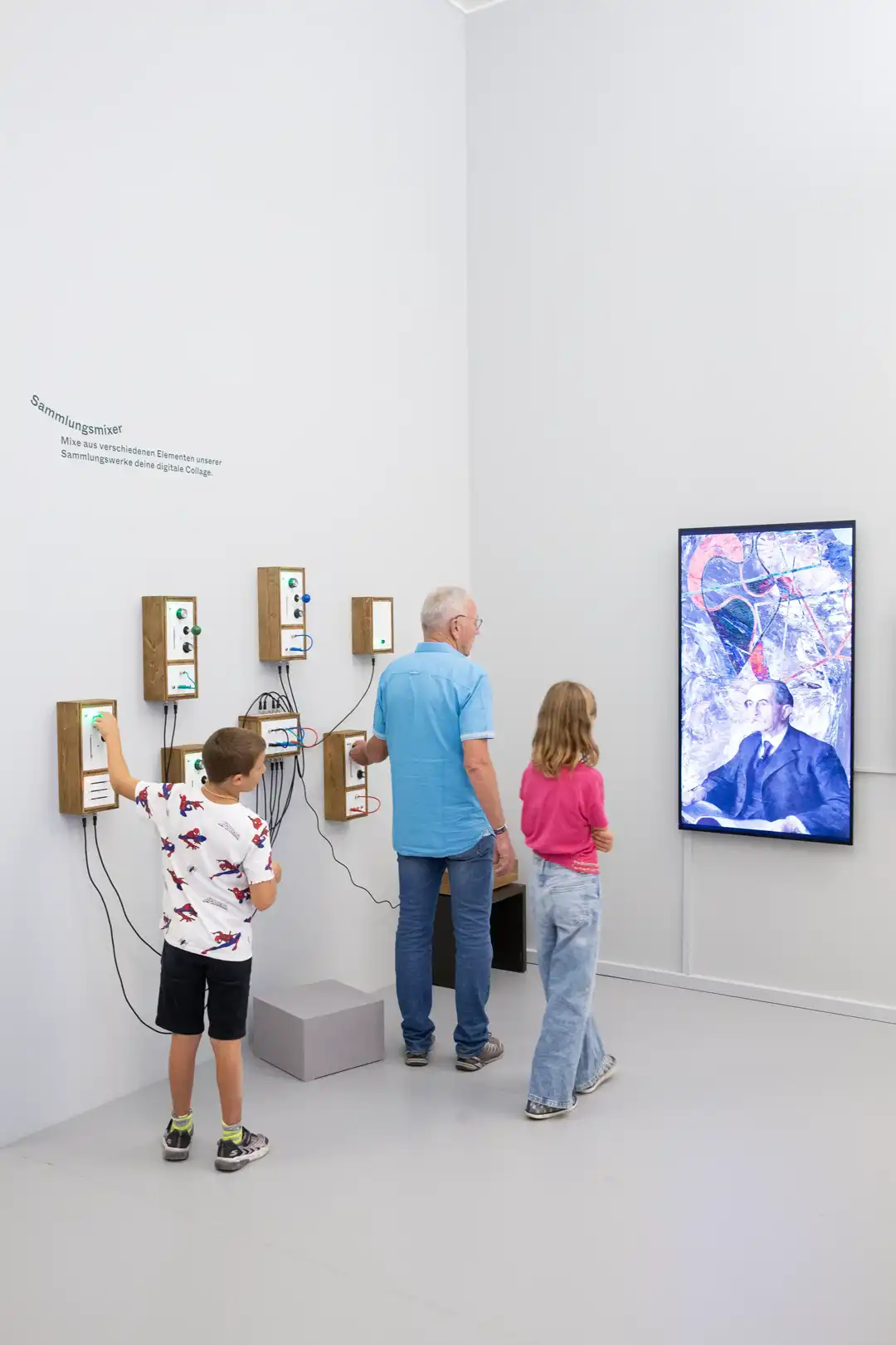Visitors using interactive collage installation in museum exhibition