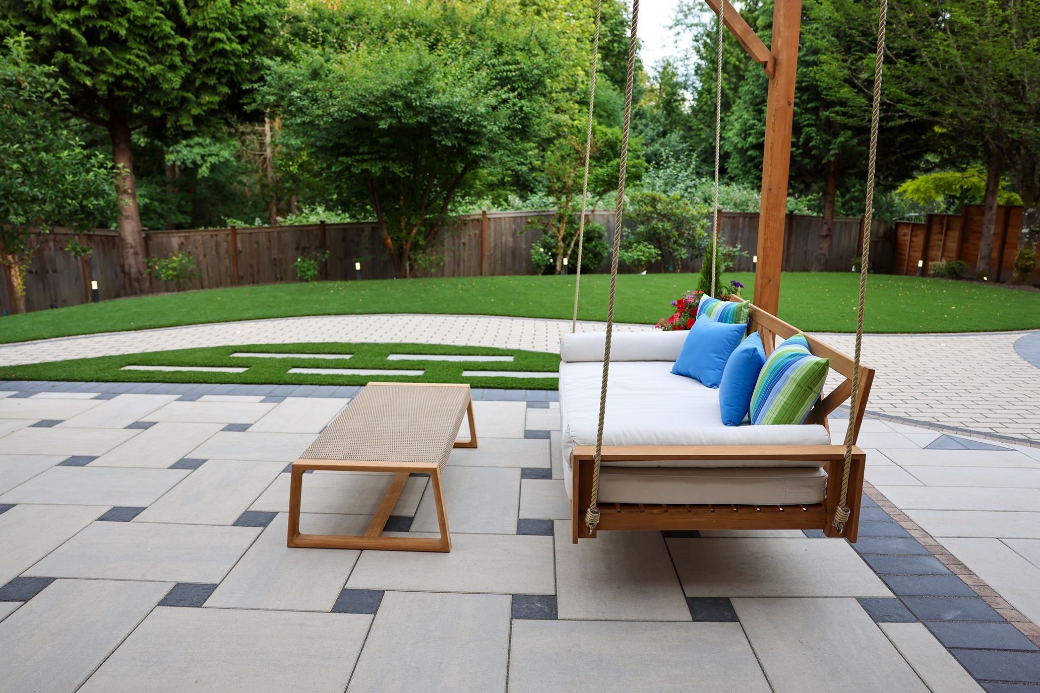 A remodeled outdoor patio with swinging sofa and coffee table