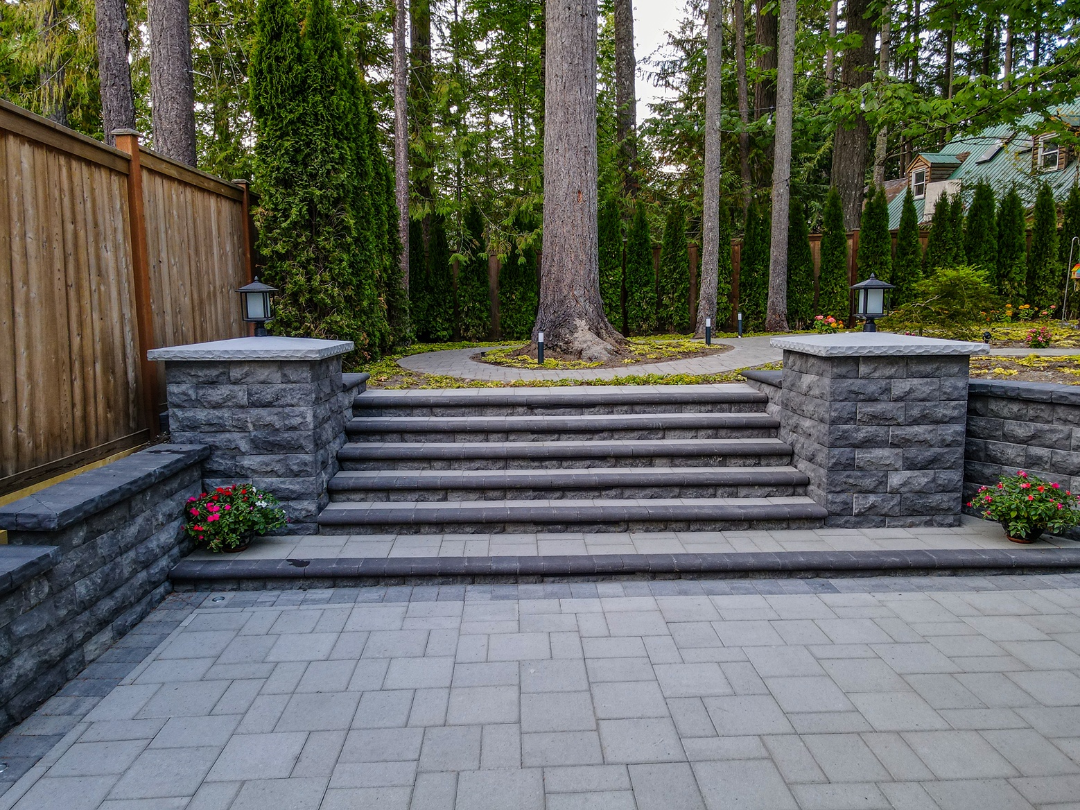A hardscaped backyard in Seattle with stairs connecting patio and garden