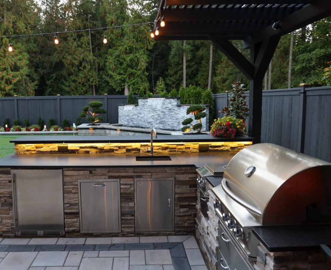 Outdoor kitchen in a backyard in Bellevue with sink and grill