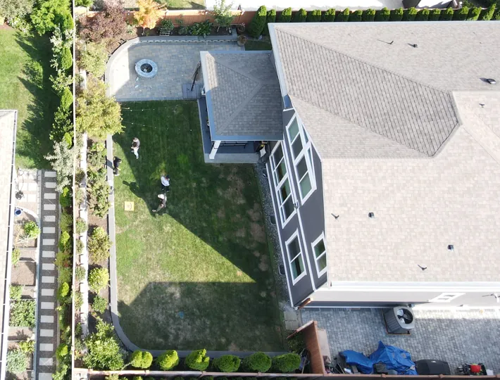 Landscape company contractors surveying a Seattle backyard