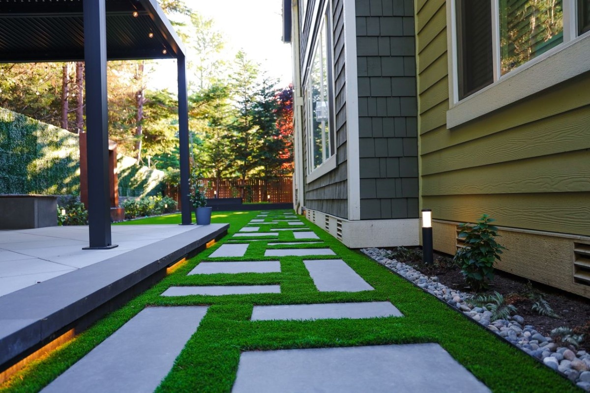 An artificial turf with custom walkway and landscape lighting