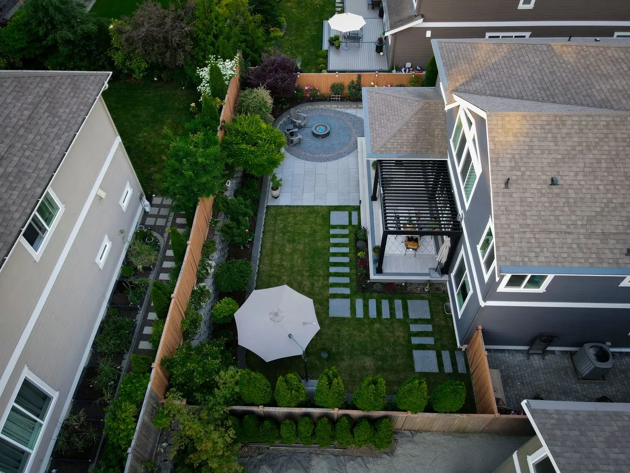 Bird's eye view of a finished backyard remodel with custom pavers and fire pit