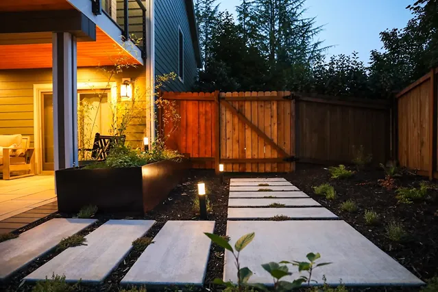 Modern illuminated stepping stone path at night.