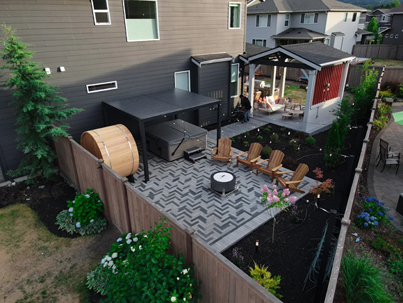 Aerial backyard view with sauna, Adirondack chairs, and patio.