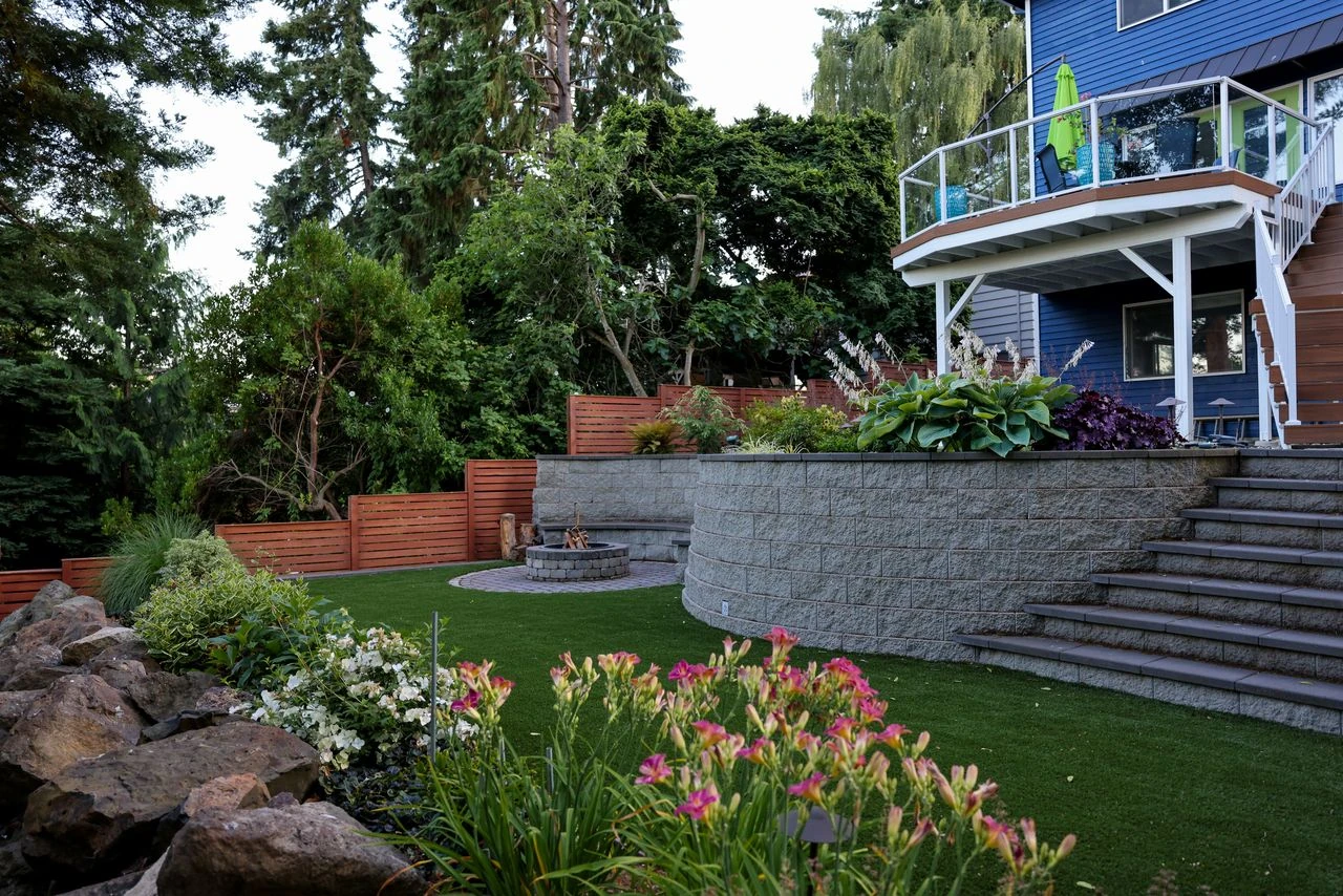 Terraced stone retaining wall, stairs, artificial turf, and elevated deck