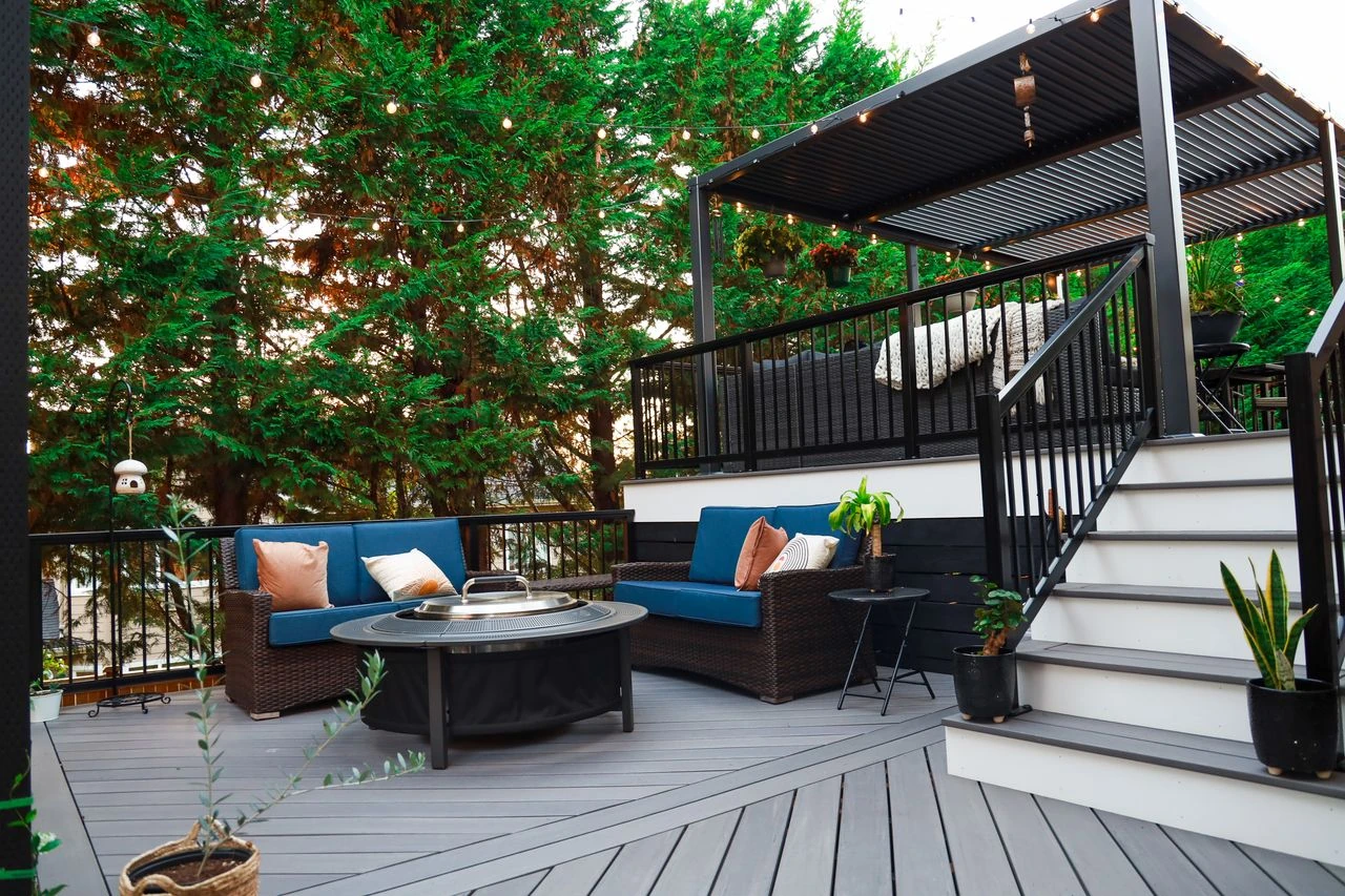 Multi-level composite deck with outdoor fire table lounge and louvered pergola
