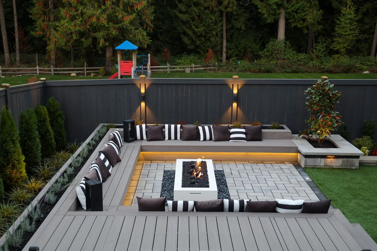 Sunken patio deck with central square fire table and built-in bench seatin