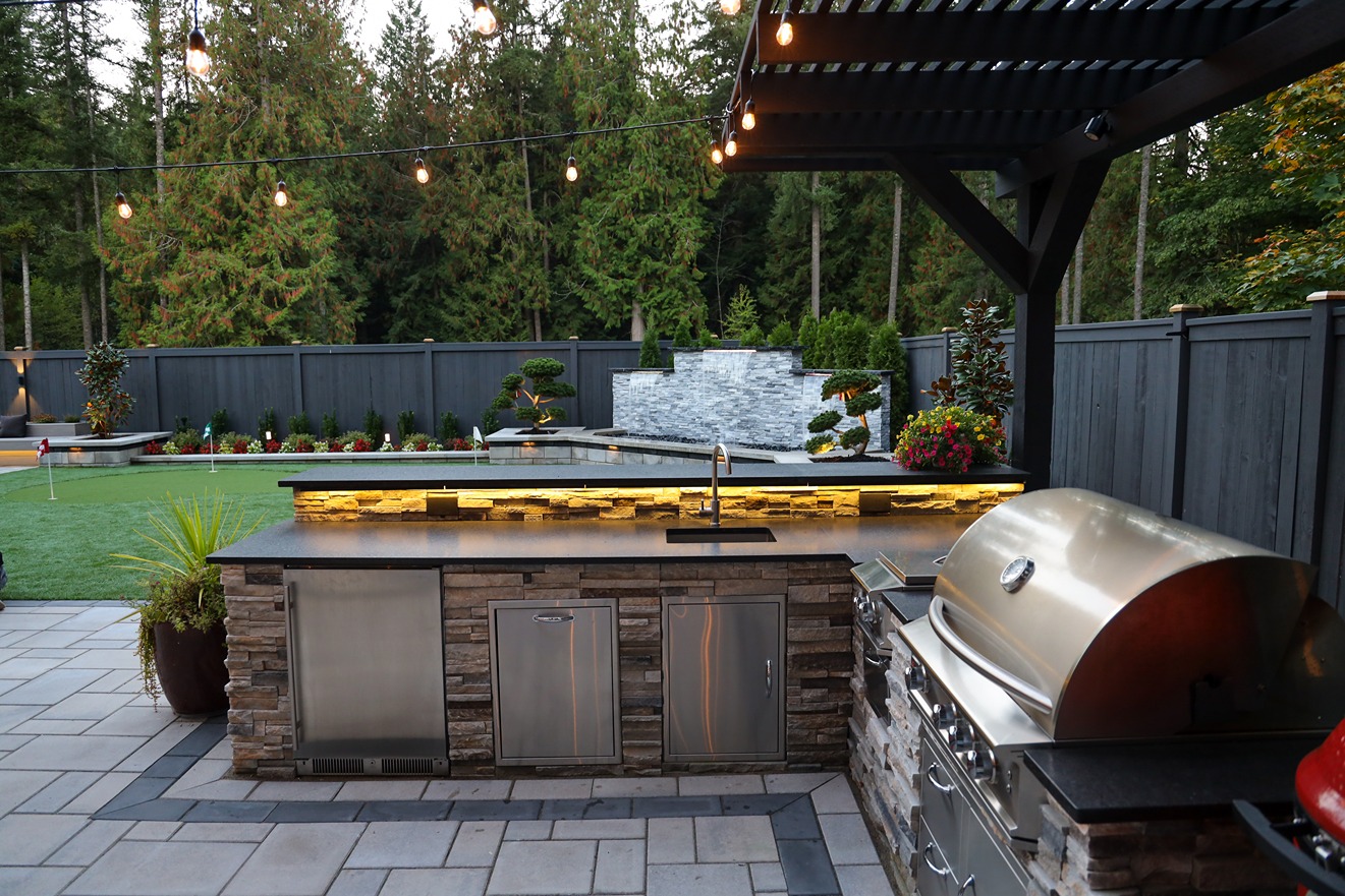 Outdoor kitchen in a backyard in Bellevue with grill and sink