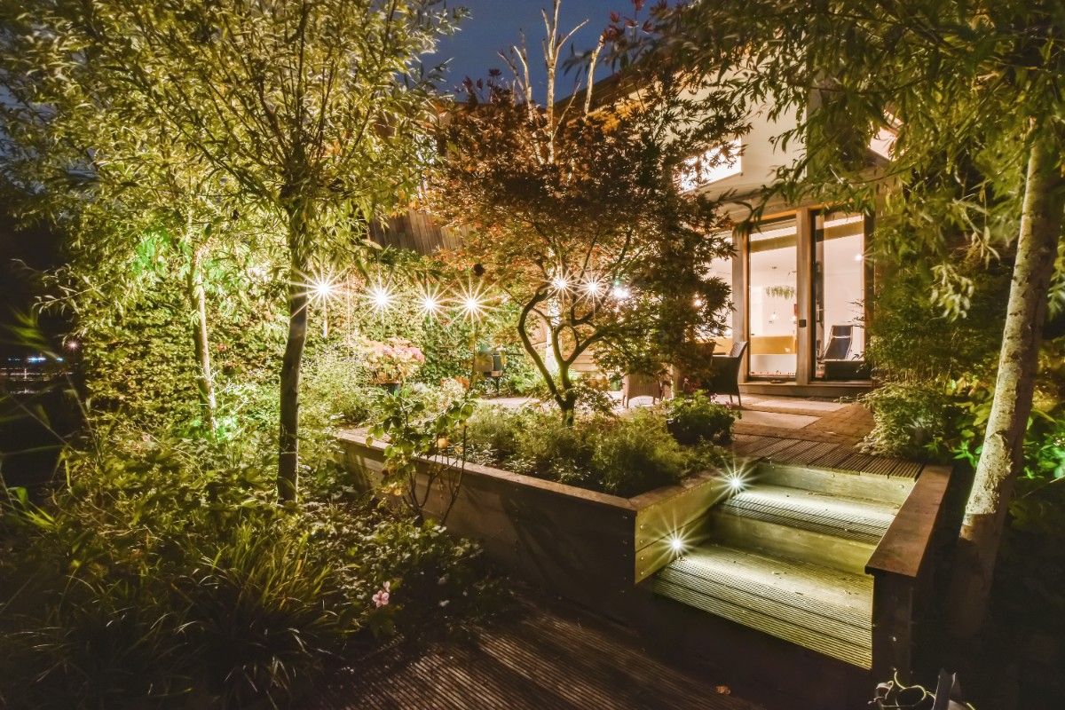Landscape design home value illustrated with layered garden beds and outdoor lighting
