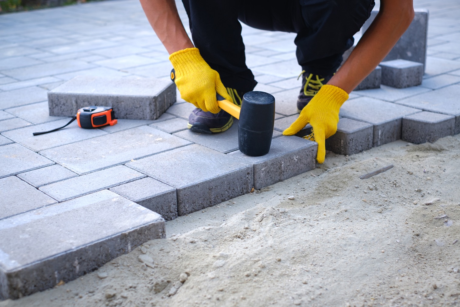 Contractor fixing the tile on floor during patio paver installation