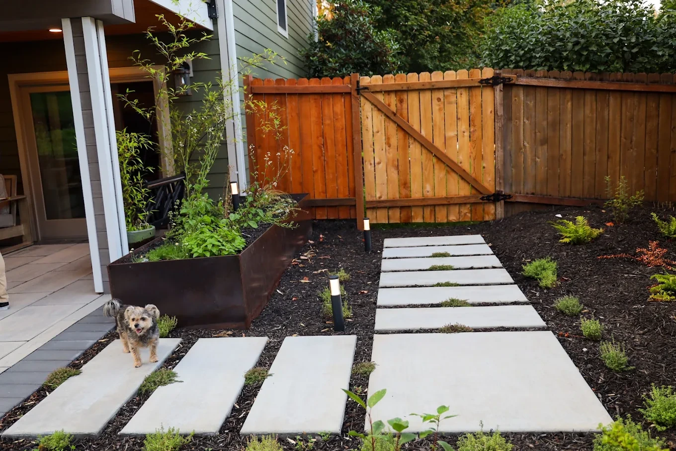 Stone patio and retaining wall on a sloped backyard