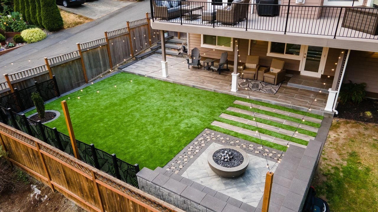 Redesigned backyard with stone patio and garden beds