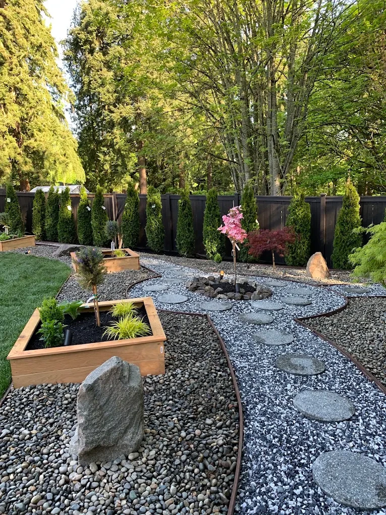 A Japanese-style garden in Snoqualmie with raised planters, stepping stones, gravel, and conifers.