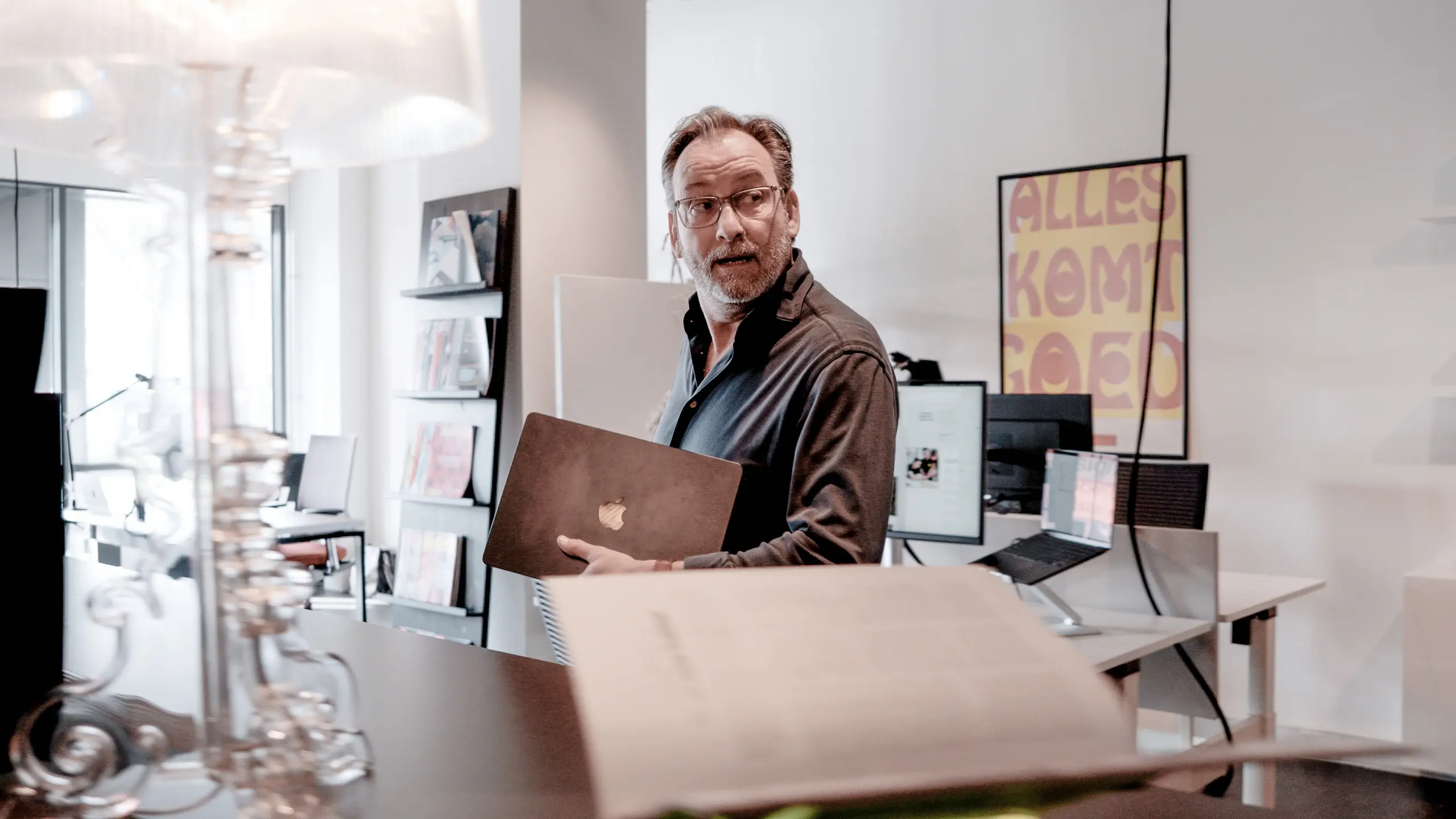 designer die met laptop door bureau loopt bij Coolbrand