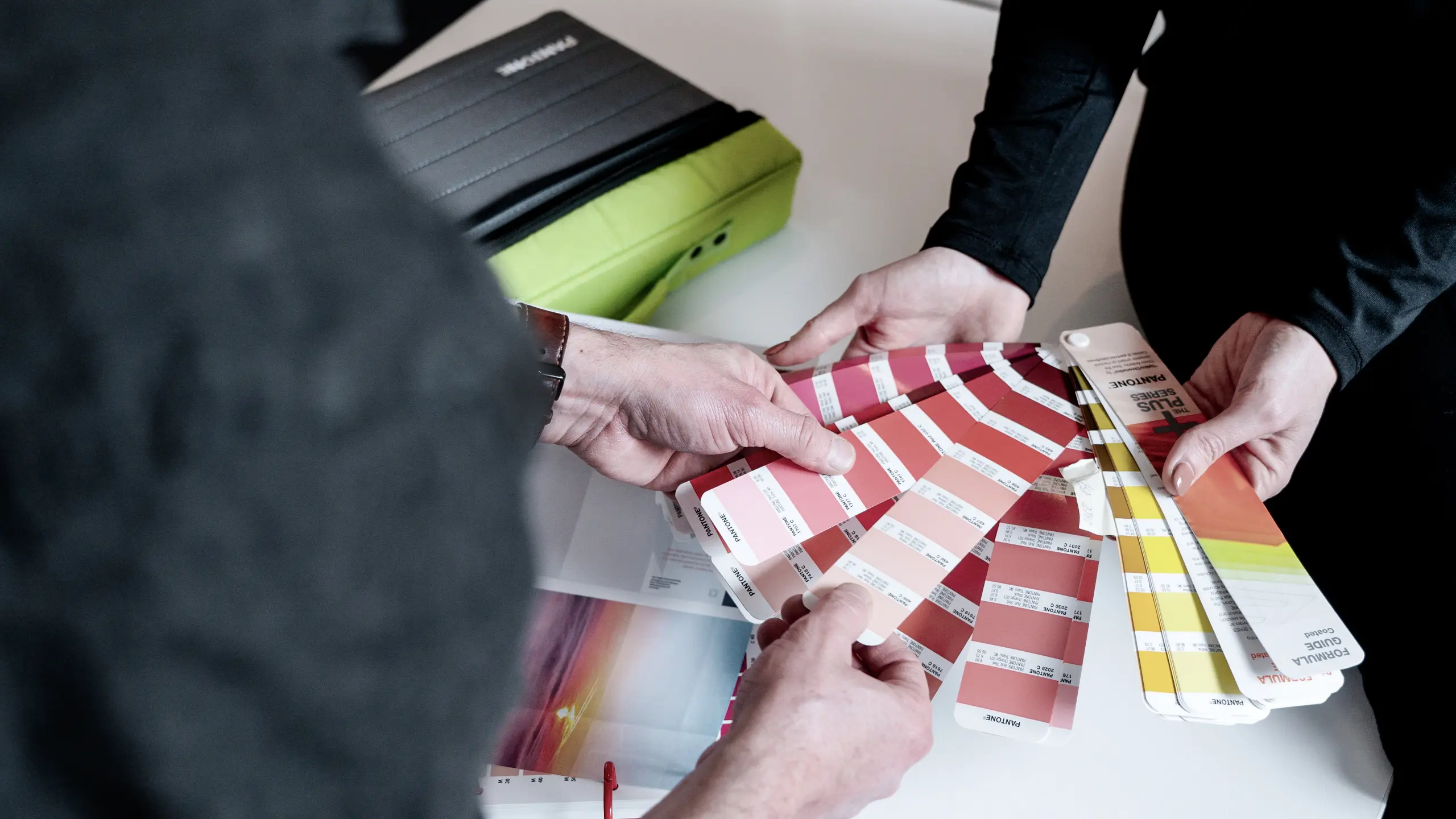 overleg communicatiespecialist en designer bij Coolbrand over kleurenpalet klant dmv kleurenwaaier
