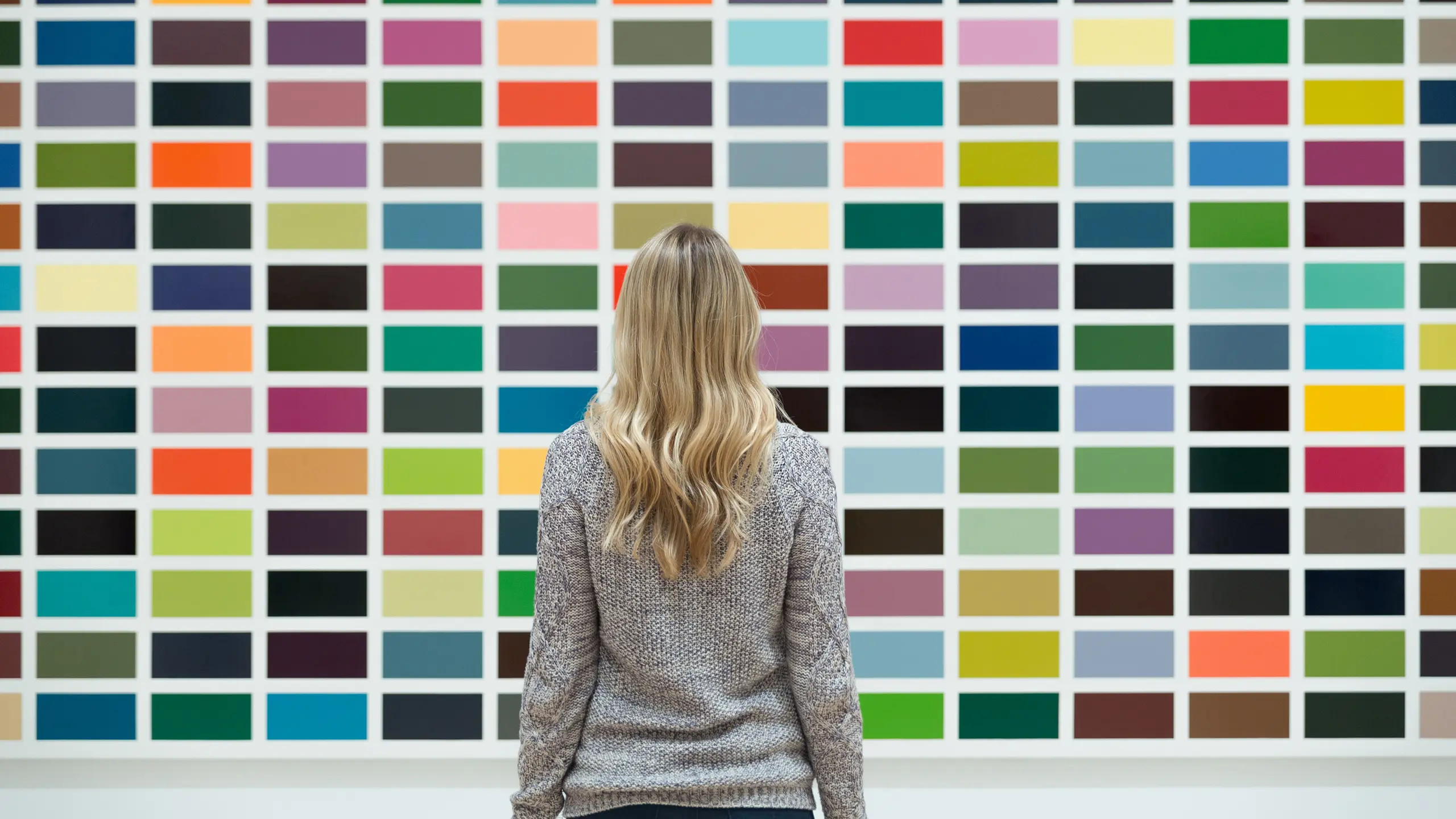 Vrouw die voor een bord met kleuren staat om te kiezen