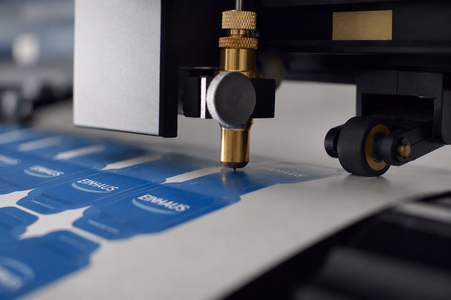 Siebdruck mit goldener Schrift 'Druck, der Eindruck hinterlässt' und geometrischen Linien auf Blau.