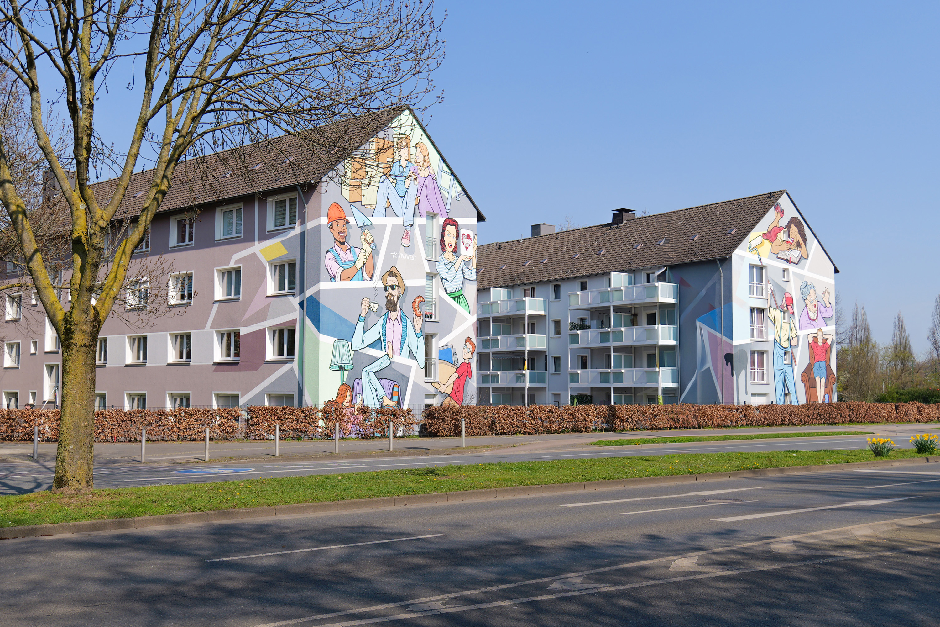 Wohnhäuser mit bunten Wandmalereien von Menschen in Alltagssituationen im sonnigen Borsigplatz.