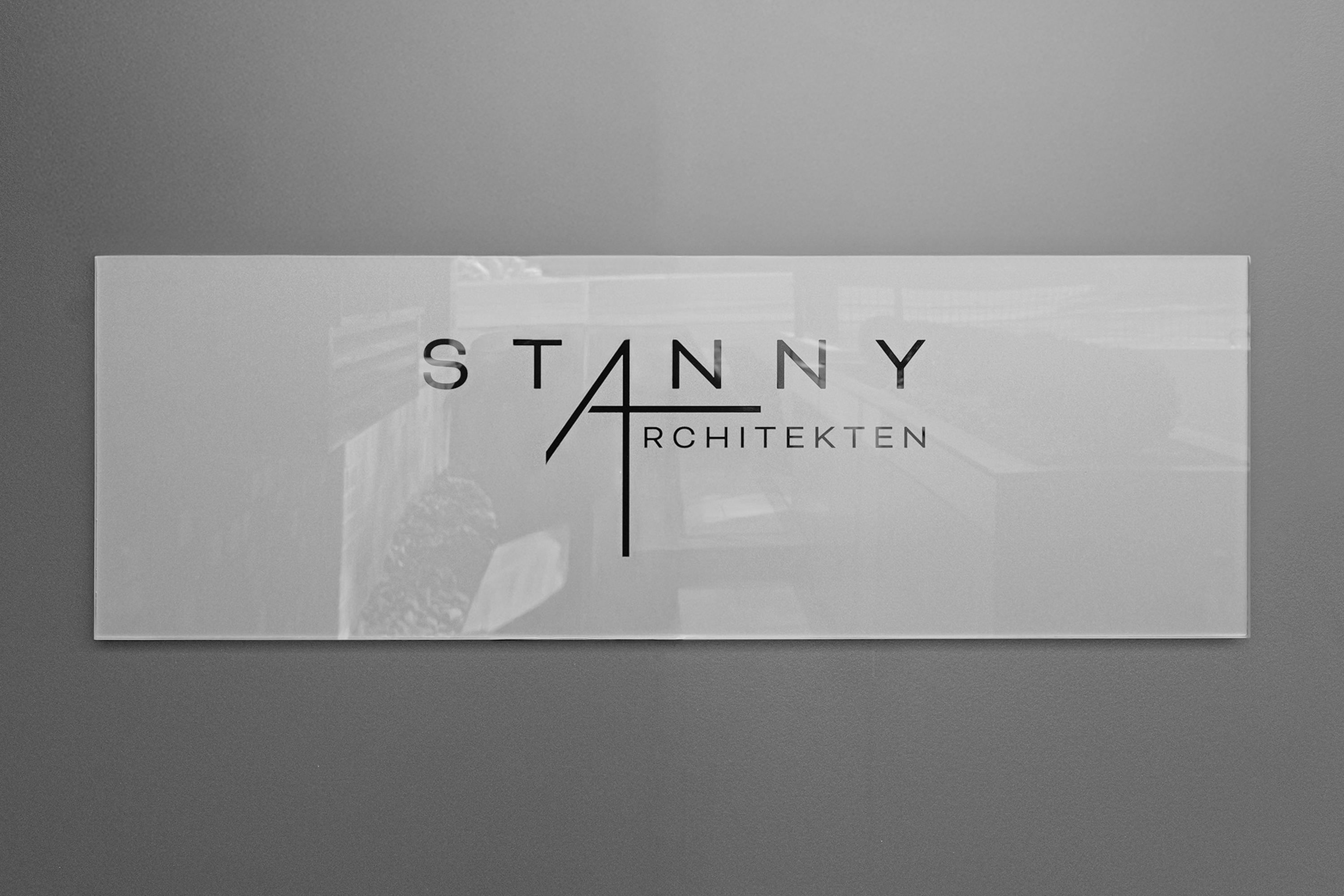 Schild mit der Aufschrift STANNY ARCHITEKTEN an einer Wand.