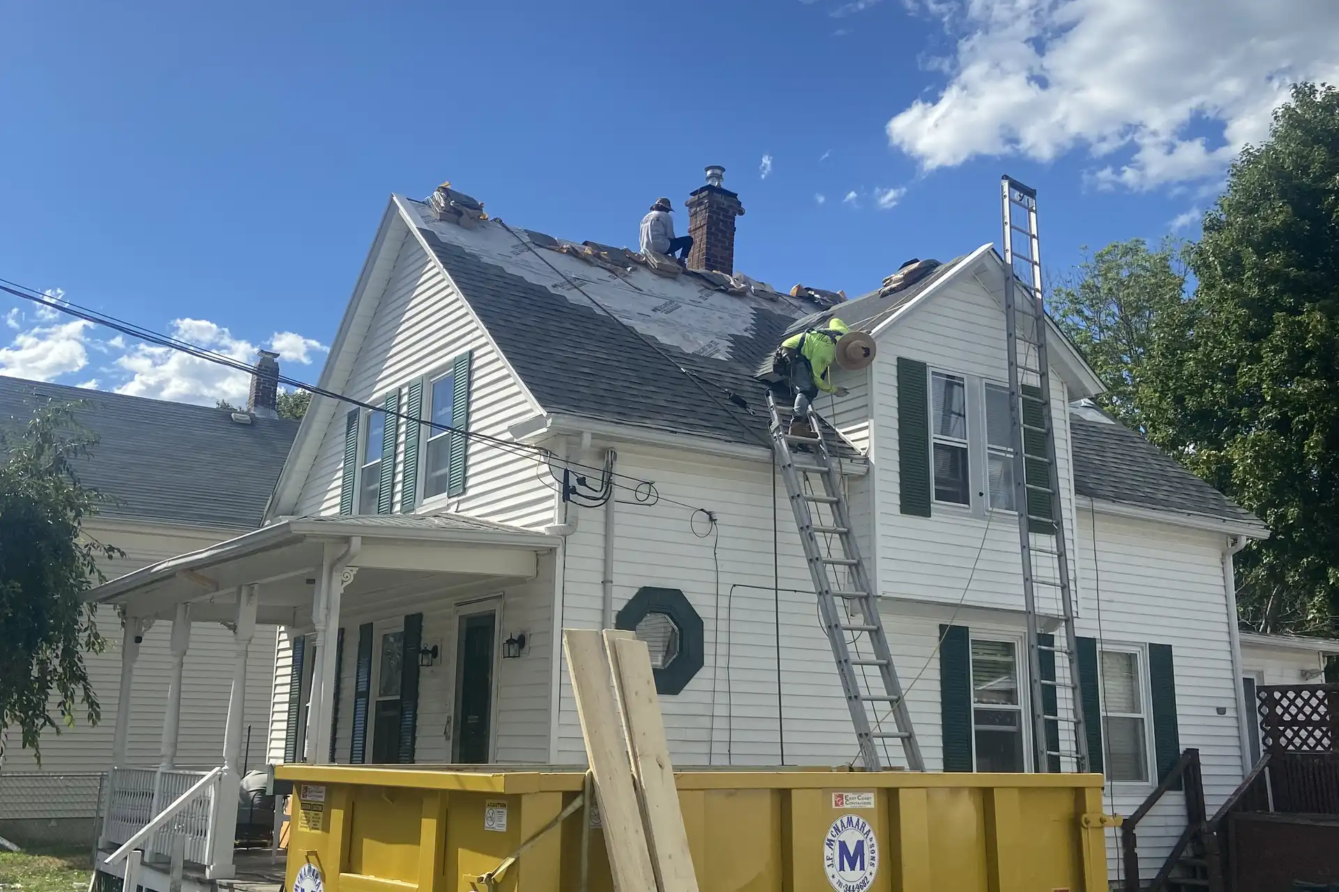 Exterior renovation work on a white multi-story home