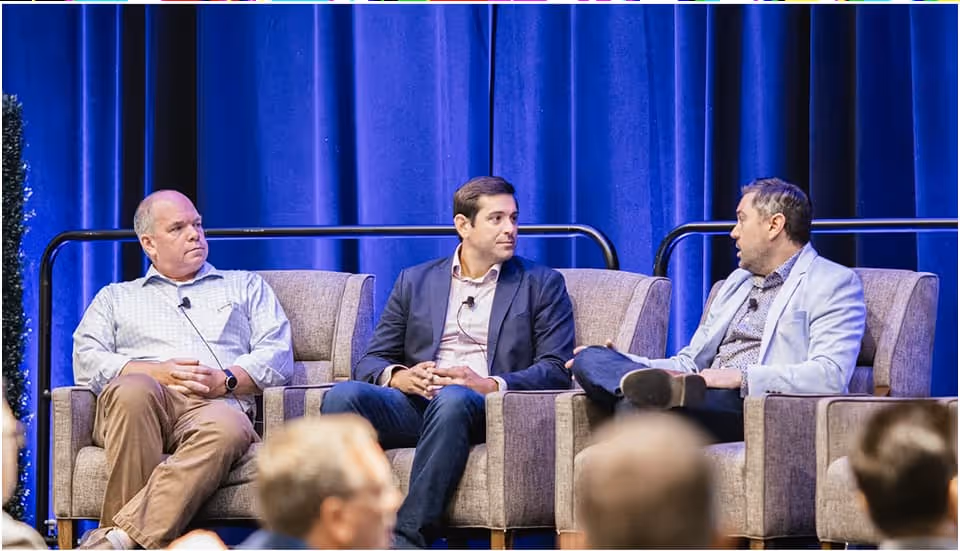Three men sitting together and having a focused discussion, possibly brainstorming ideas or engaged in a collaborative meeting.
