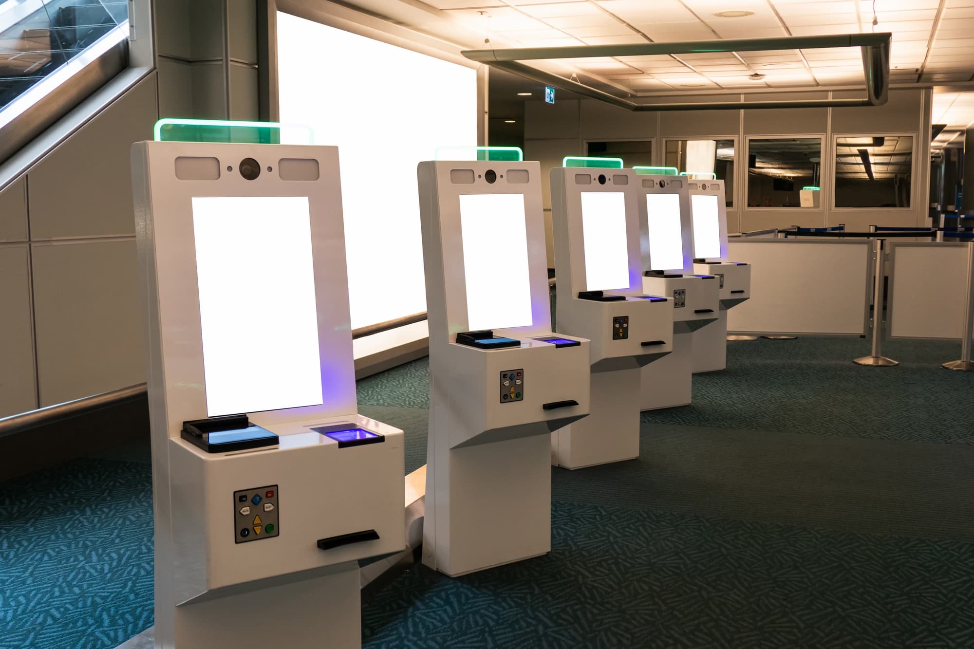 Row of Self service card dispenser with passport scanner touch screen in immigration zone at the airport