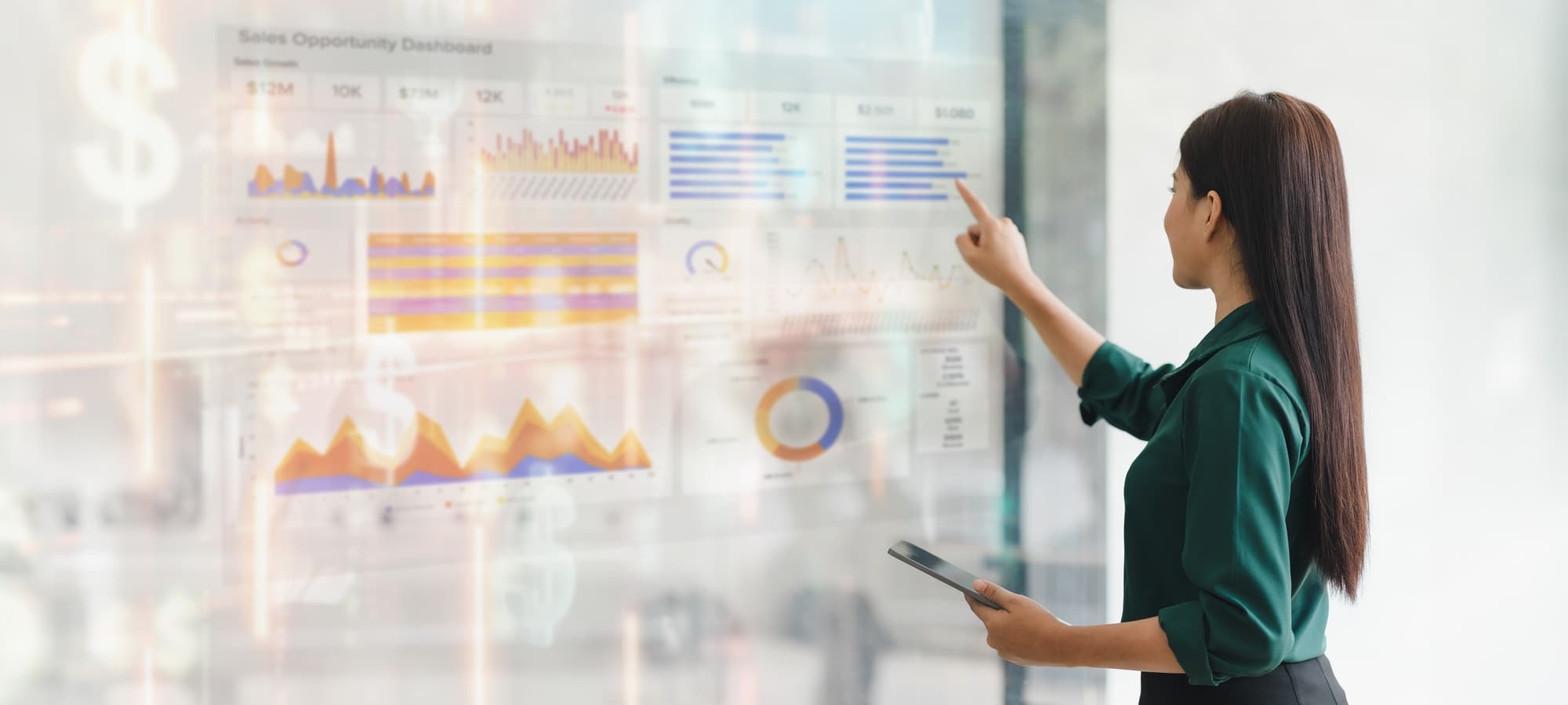 Professional woman interacting with digital sales dashboard displaying various charts and graphs in modern office