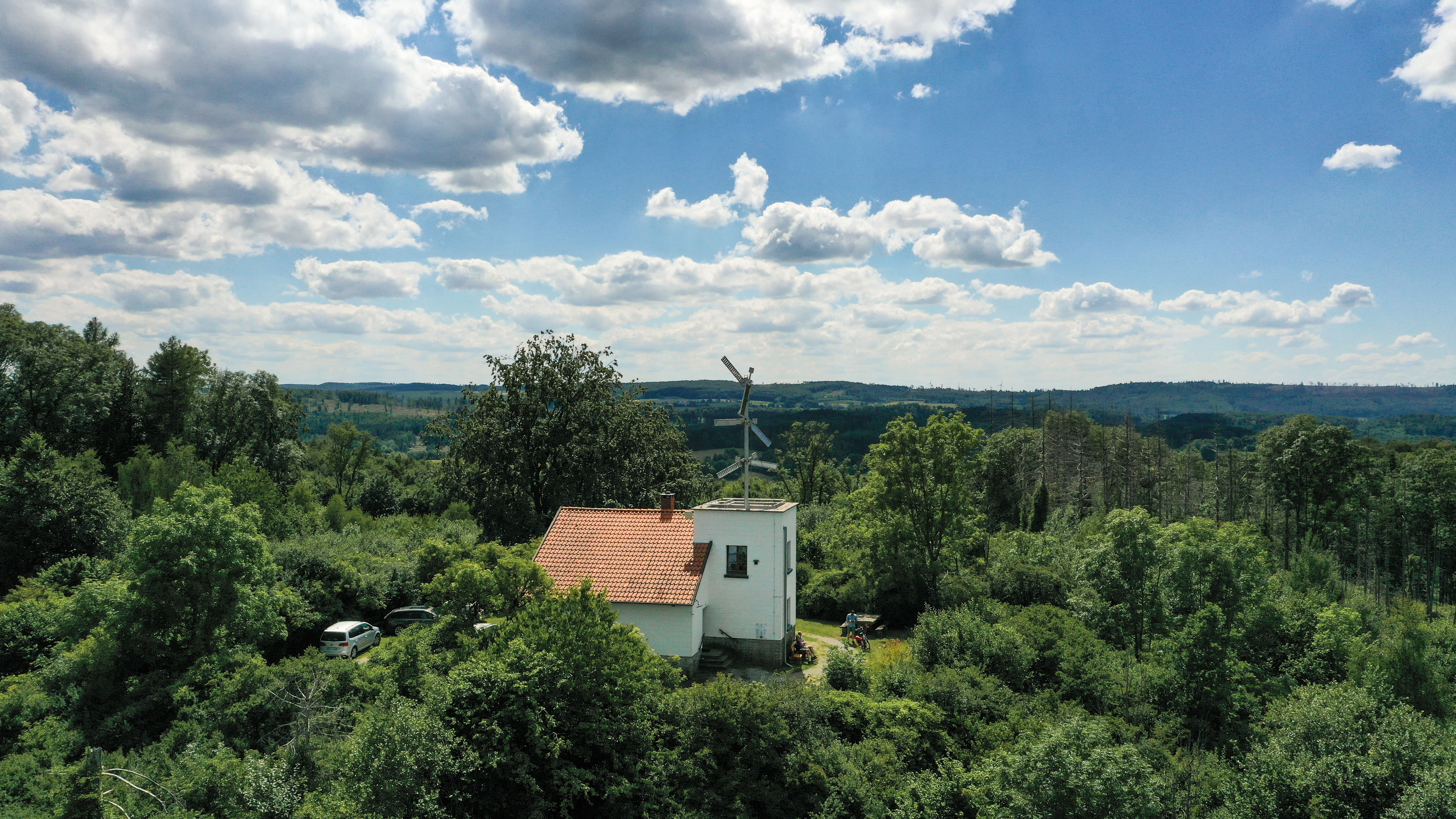 Telegrafenstation 32 umgeben von dichtem grünem Wald unter einem bewölkten Himmel.