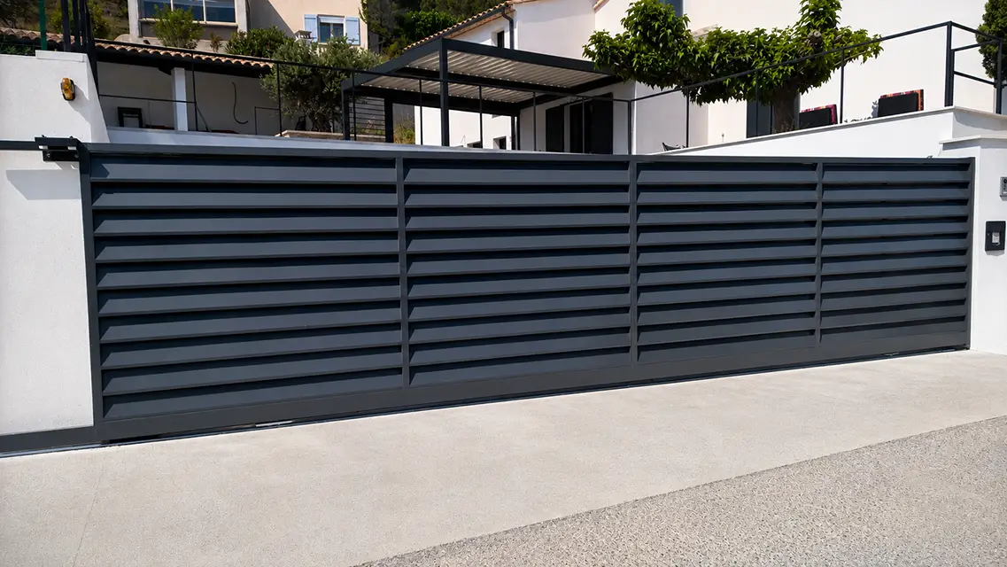 Portail coulissant aluminium moderne à l'entrée d'une propriété.