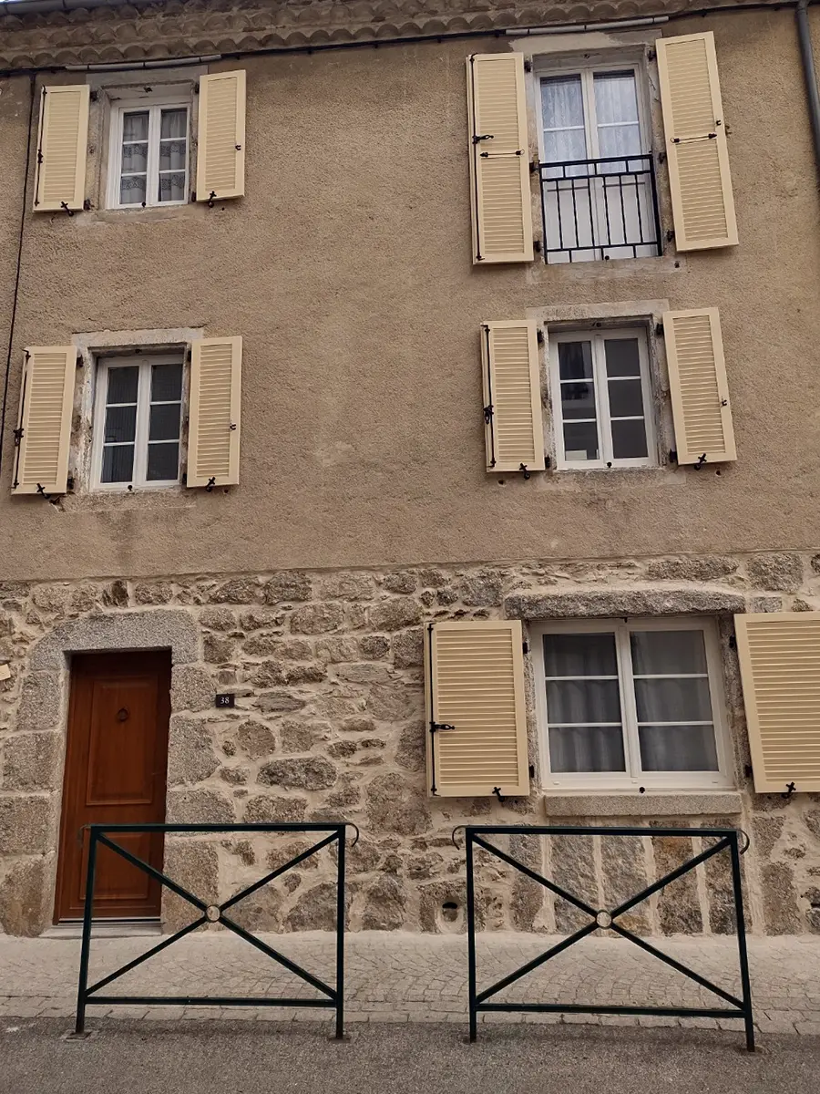 Volet aluminium persienné blanc installé sur une façade claire.