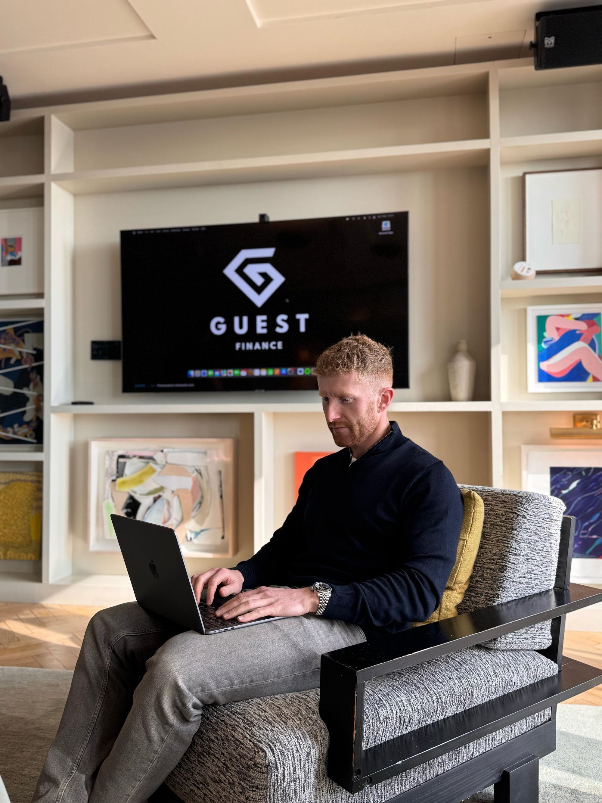 CEO Arran Guest using a laptop sitting in the Guest Finance office