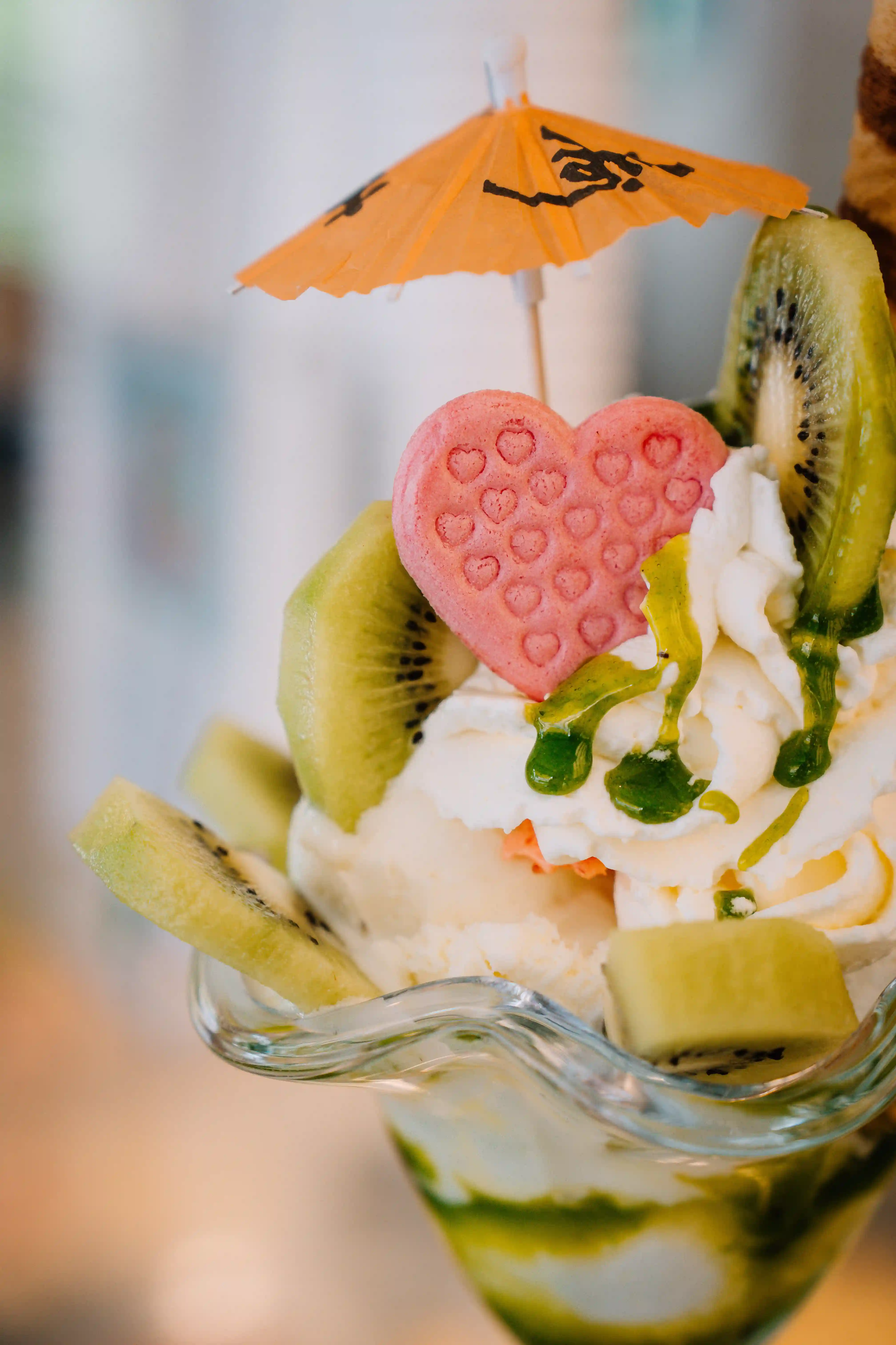 Ein Kiwi-Eisbecher mit lecker Kiwi-Scheiben, Zucker-Herz und fruchtigen Eis.