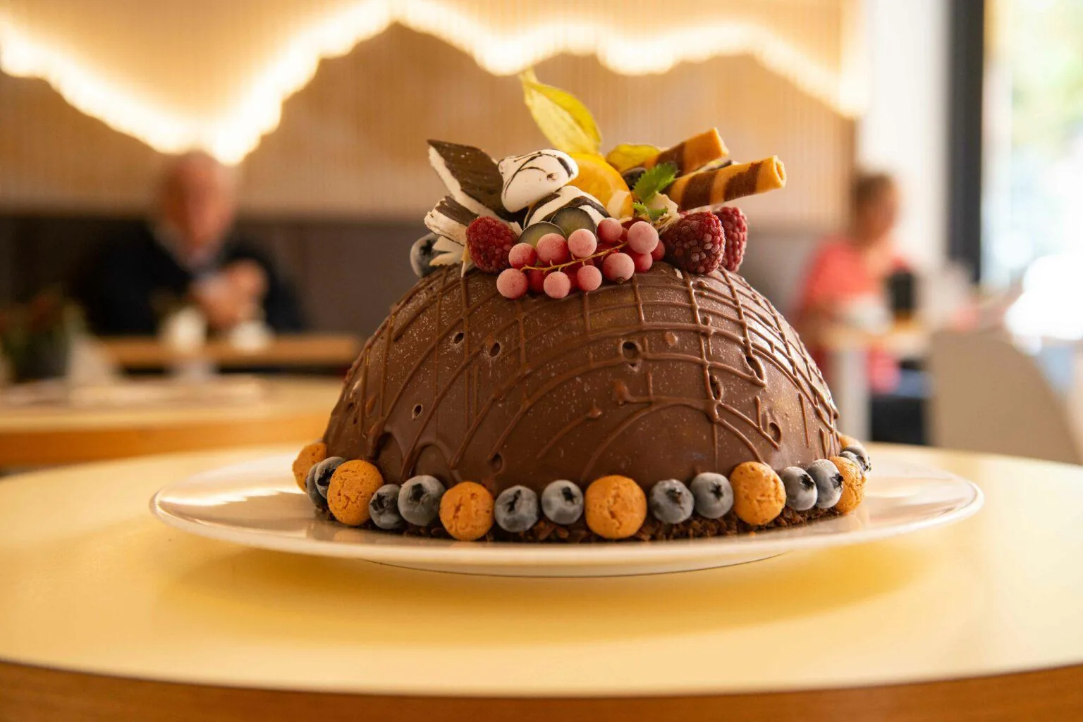 Eine schokolierte Eisbombe. Mit Früchten und Waffeln dekoriert.