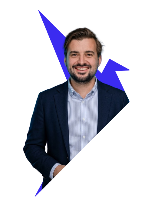 Smiling man with beard wearing a navy blazer and striped shirt
