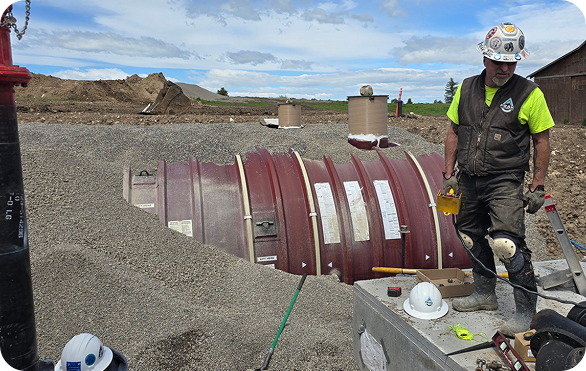Storage & Structures tank in gravel near yellow excavators